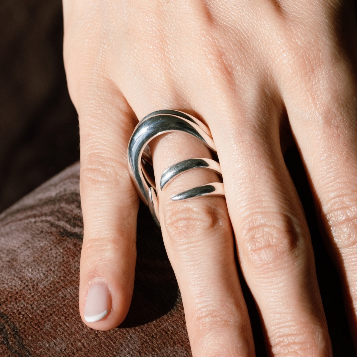 Georg Jensen Arc ring in silver, its layered sweeping bands wrapping the finger.