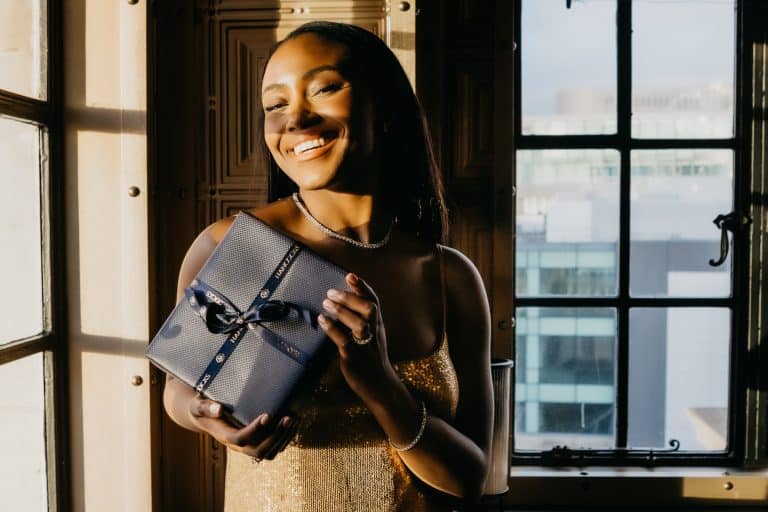 Young lady holding a gift box tied up with a bow