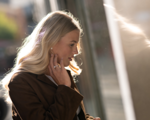 Lady wearing jewellery during autumn looking outside a shop