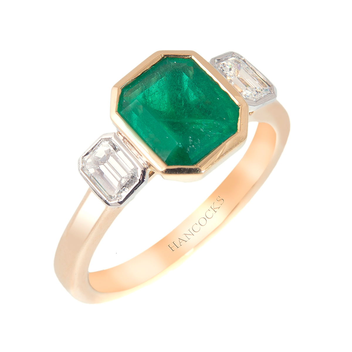 emerald three stone ring with rubbed over settings